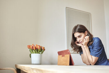 Young woman reading digital tablet at dining table - CUF18225