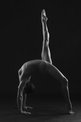 Full length side view of nude dancer in crab position leg raised, b&w - ISF06831