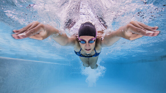 Unterwasseransicht von Teenager-Mädchen schwimmen im Pool - ISF06875