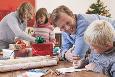 Familie verpackt Weihnachtsgeschenke - CUF18259