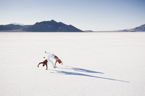 Erhöhte Ansicht von zwei Männern, die Capoeira auf den Bonneville Salt Flats, Utah, USA, ausführen - CUF18422