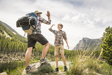 Full length view of father and son doing high five, Red Lodge, Montana, USA - ISF07004