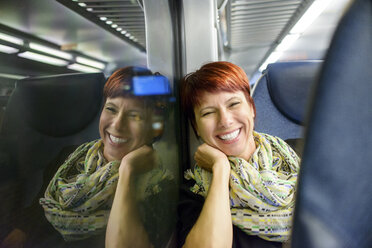 Porträt einer reifen Frau im Zug sitzend bei Nacht - ISF07030