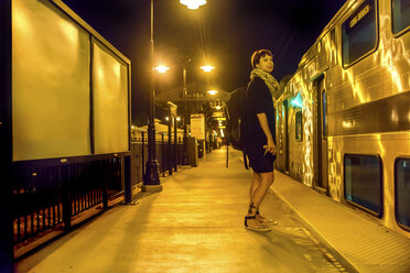 Ältere Frau steht nachts auf dem Bahnsteig - ISF07031