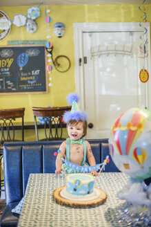 Baby-Junge trägt Party-Hut mit ersten Geburtstagskuchen am Tisch - ISF07049
