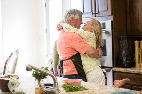 Älteres Paar, das sich in der Küche umarmt - ISF07057