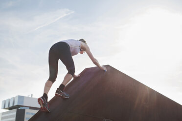 Woman training, moving up urban footbridge - CUF18483