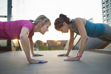 Two women training, doing push ups on stairway - CUF18522