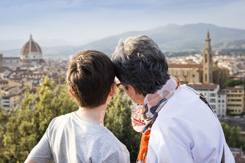 Ältere Frau und Enkel mit Blick auf eine Stadtlandschaft, Florenz, Italien, lizenzfreies Stockfoto
