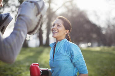 Junge Frau beim Boxtraining im Park - CUF18528