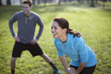 Young man and woman doing warm up training in park - CUF18533