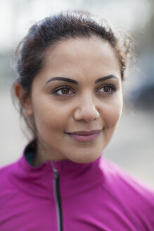 Porträt einer jungen Frau, die einen rosa Trainingsanzug zum Training trägt - CUF18541