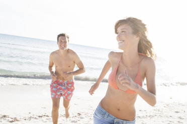 Man chasing girlfriend on beach, Majorca, Spain - CUF18546