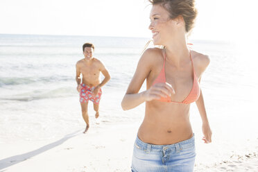 Man running and chasing girlfriend on beach, Majorca, Spain - CUF18547