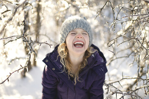 Portrait of young girl laughing, in snowy landscape - CUF18738