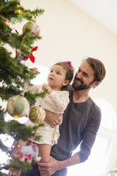 Vater und Tochter schmücken den Weihnachtsbaum - ISF07111