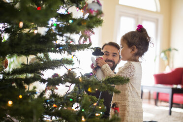 Father and daughter decorating christmas tree - ISF07113
