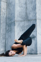 Frau in Arm-Balance-Haltung (Eka Pada Koundinyasana) - ISF07143