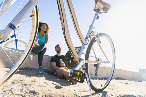 Couple relaxing after bike ride, bicycles beside them - ISF07178