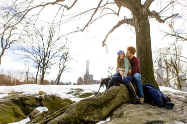 Romantisches junges Paar sitzt mit Hund im verschneiten Central Park, New York, USA - ISF07226