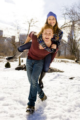 Junger Mann nimmt seine Freundin im verschneiten Central Park, New York, USA, huckepack - ISF07230