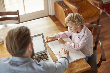 Father helping son with homework in home office - CUF18914