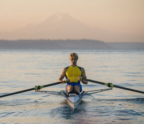 Teenage boy in sculling boat on water - ISF07235