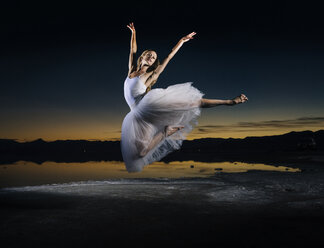 Junge Balletttänzerin springt bei Sonnenuntergang über die Bonneville Salt Flats, Utah, USA - ISF07251