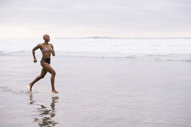 Frau im Bikini joggt am Strand - ISF07254