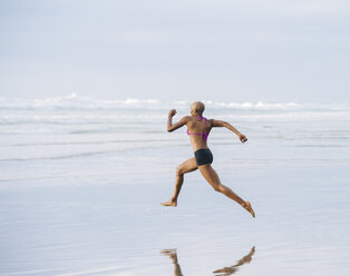 Frau im Bikini sprintet am Strand - ISF07256