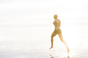 Frau im Bikini joggt am Strand - ISF07257