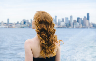 Rückansicht einer Frau, die von einer Passagierfähre auf dem Puget Sound, Seattle, USA, hinausschaut - ISF07266