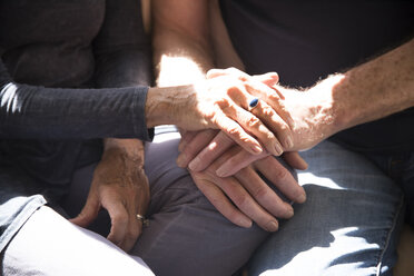 Älteres Paar, das zusammensitzt und sich die Hände berührt, Mittelteil, Nahaufnahme - ISF07366