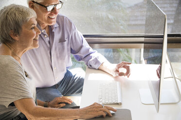 Senior couple using computer, looking at computer screen - ISF07368