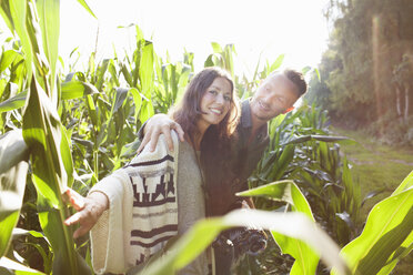 Couple amongst corn plants in field - ISF07400