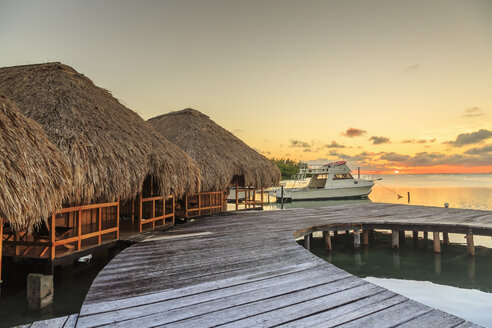 Chalets am Wasser und vertäutes Motorboot, St. Georges Caye, Belize, Mittelamerika - ISF07413