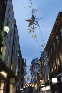 Sternförmige Weihnachtsdekoration über einer Straße in der Abenddämmerung, London, UK - CUF19027