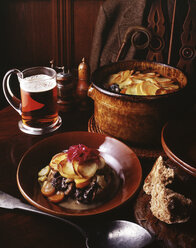 Hirschragout, mit Rotkohl, Kartoffelscheiben, Karotten, Zwiebeln und Lauch, dazu ein Glas Ale und Vollkornbrot - CUF19028