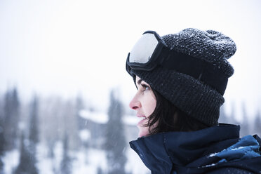 Porträt einer jungen Frau mit Skibrille, die in den Schnee blickt, Brighton Ski Resort außerhalb von Salt Lake City, Utah, USA - CUF19104