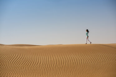 Touristin beim Spaziergang auf einer Wüstendüne, Dubai, Vereinigte Arabische Emirate - CUF19136