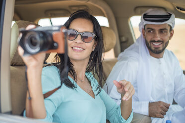 Female tourist in off road vehicle in desert taking photographs, Dubai, United Arab Emirates - CUF19143