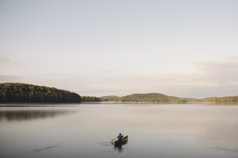 Senior woman canoeing on lake, rear view stock photo