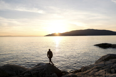 Mittlerer erwachsener Mann auf einem Felsen stehend, Blick über den See, Rückansicht - CUF19231