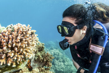 Young woman looking at hard and soft corals whilst scuba diving, Moalboal, Cebu, Philippines - CUF19283