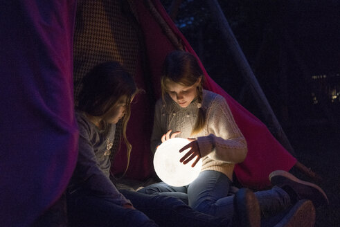 Two girls sitting in tipi, holding lamp as moon - MOEF01224