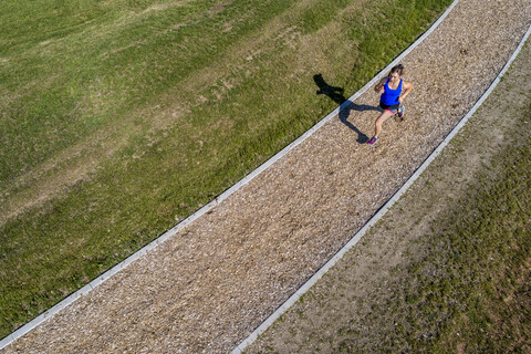 Luftaufnahme einer Joggerin auf dem Holzschnitzelweg, lizenzfreies Stockfoto