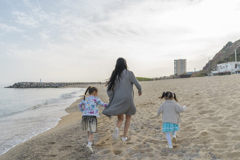 Mutter mit zwei Töchtern läuft am Strand - AFVF00568