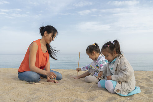 Mutter mit zwei Töchtern am Strand sitzend - AFVF00570