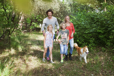 Familie mit Hund beim gemeinsamen Spaziergang im Wald - CUF19611