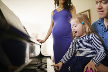 Eltern bringen ihrer Tochter das Klavierspielen bei - CUF19627